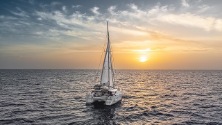 Un voilier est sur la mer au coucher du soleil.
