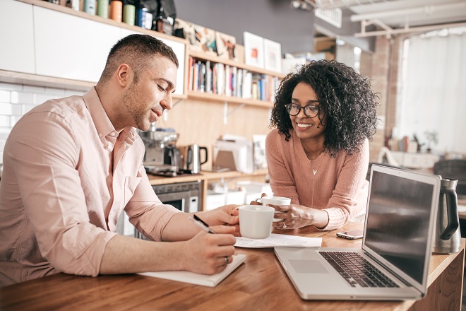 Man and woman having coffee in their kitchen and discussing their taxes