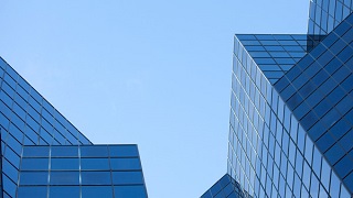 A geometric skyline of buildings and the blue sky.